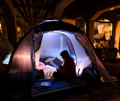 homeless reading in tent